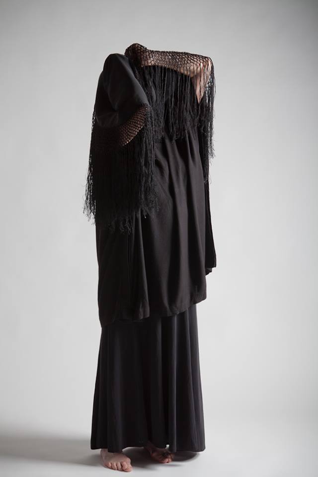 A body shrouded in black fabric